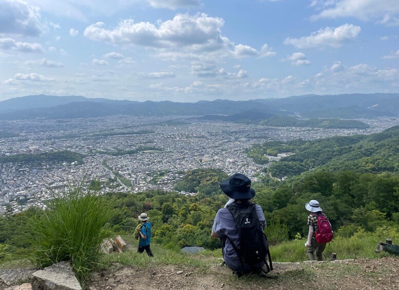 A hiker overlooking a cityscape with mountains in the background. 4