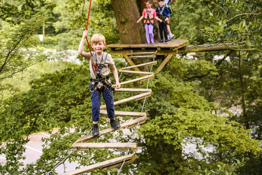 A child on a wooden bridge in a forested area. 1