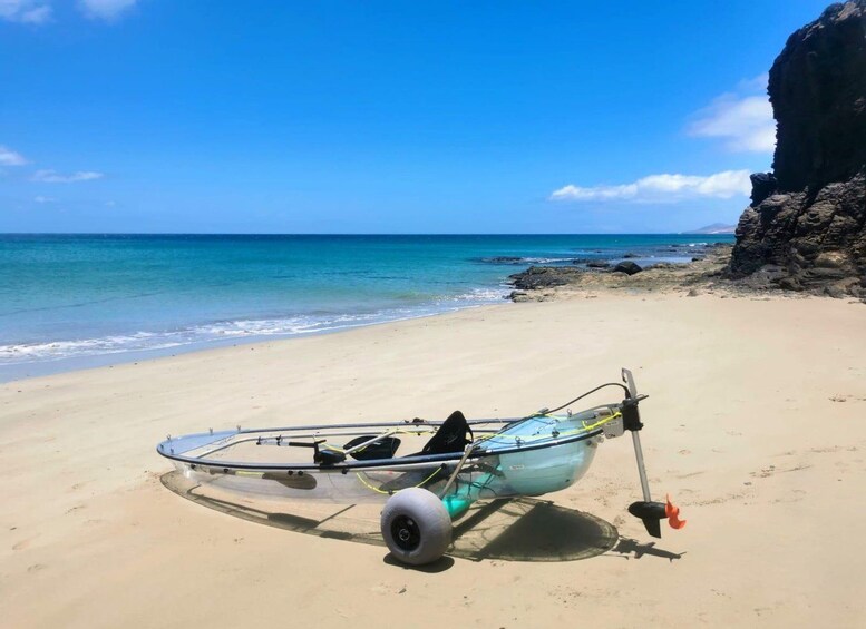A beach with a kayak and a surfboard. 5