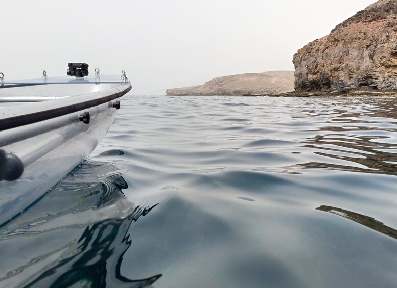 A boat on calm water with a rocky shoreline in the background. 4