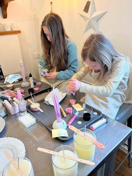 Two individuals engaged in a crafting activity with various materials on a table. 2