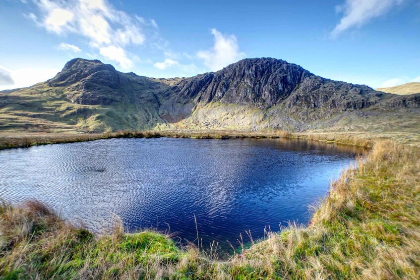 A mountain lake surrounded by grassy hills. 2