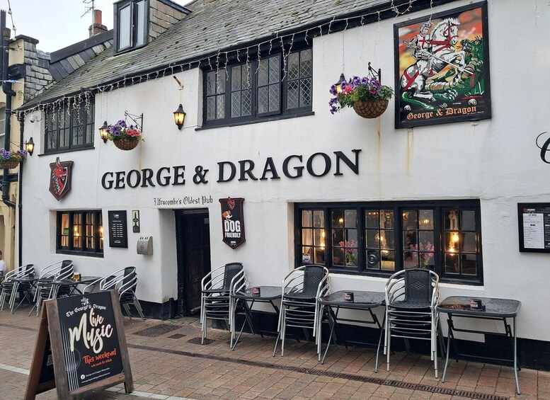A pub named 'George & Dragon' with outdoor seating and a sign advertising a music event. 5