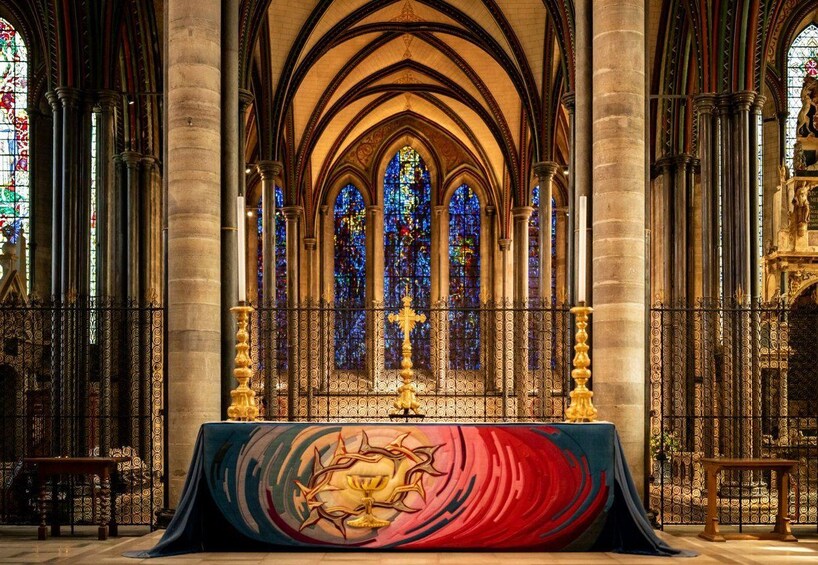A cathedral interior with stained glass windows, a central altar, and Gothic arches. 3