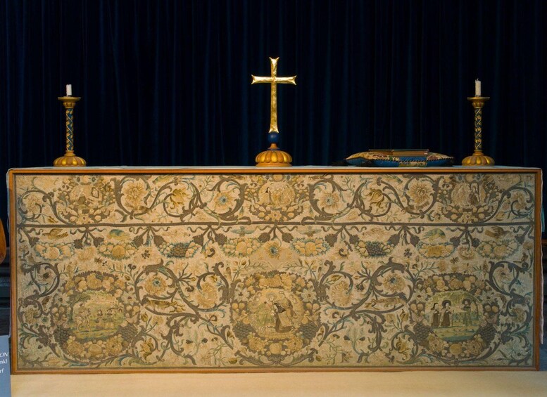 A religious altar with a cross, candles, and a detailed floral tapestry. 5