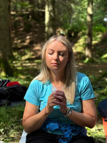 A person sitting outdoors with a forest in the background. 5