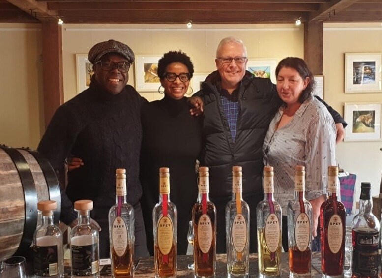 A group of people standing in a bar with various bottles of liquor on the counter. 3