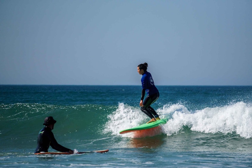 Two surfers on a wave with a clear sky. 1