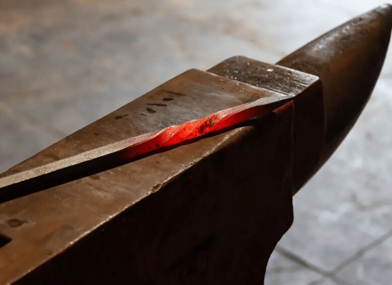 A close-up of a metal object being heated in a forge. 1