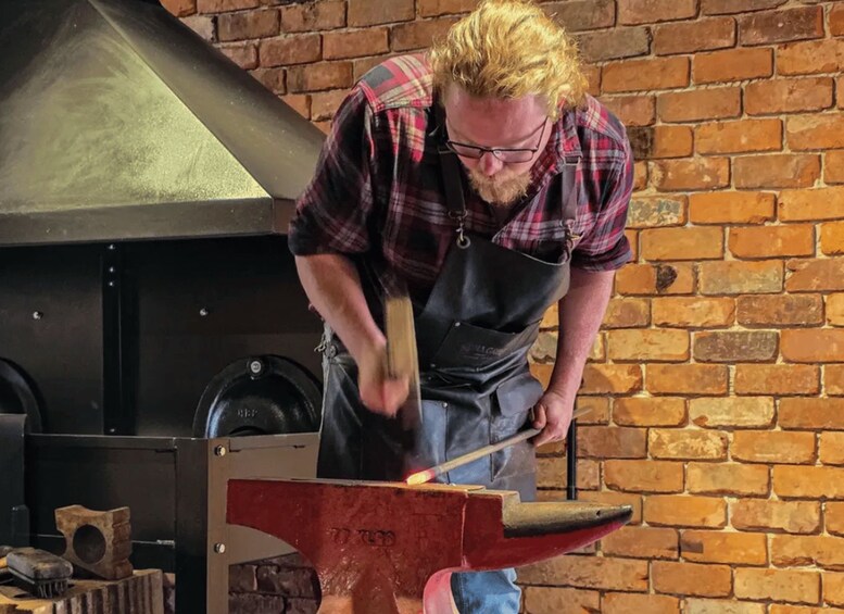 A person working with a forge, hammering a piece of metal on an anvil. 3