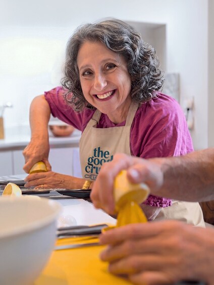 A person squeezing lemon juice into a bowl. 1