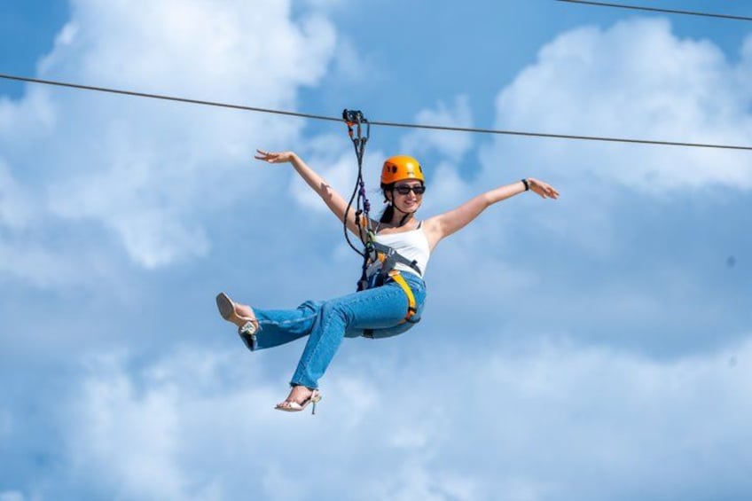 A person bungee jumping with a harness and helmet against a blue sky. 1