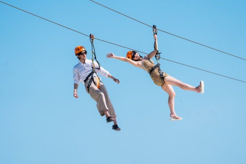 Two people ziplining in the air. 5