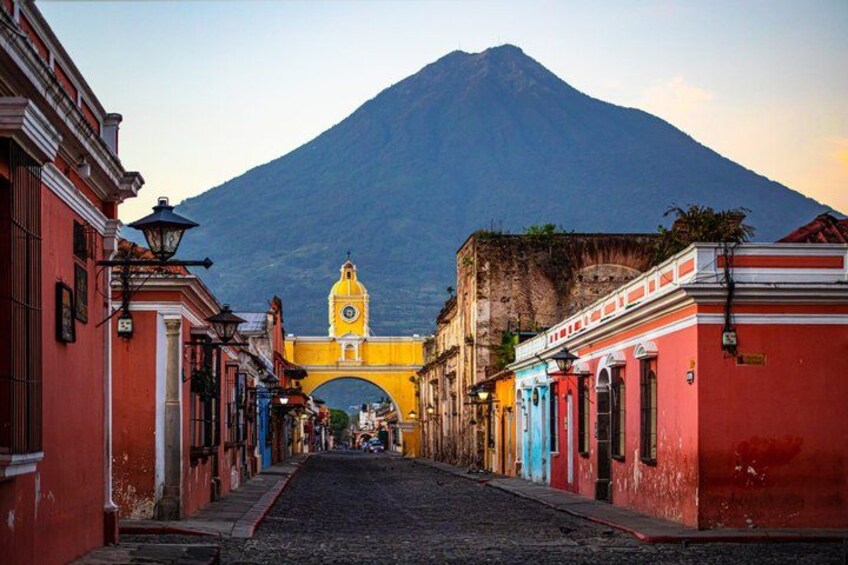 A street with colorful buildings, a yellow archway, and a mountain in the background. 5