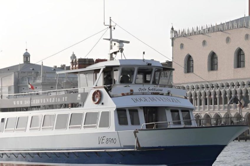 A boat named 'Ice Breaker' docked at a pier with a historic building in the background. 2