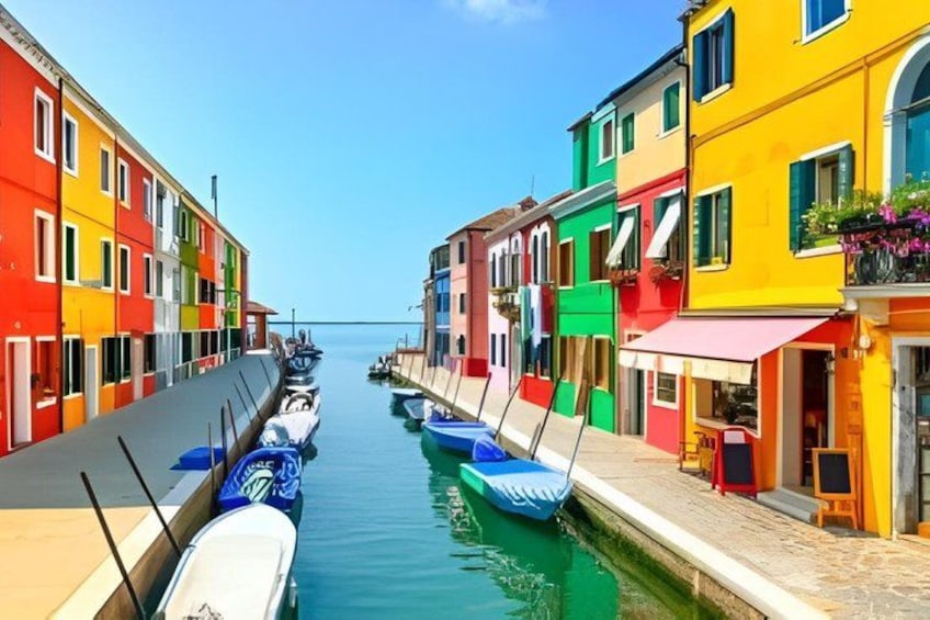 A canal with colorful buildings on either side, boats docked along the water, and a clear blue sky. 4
