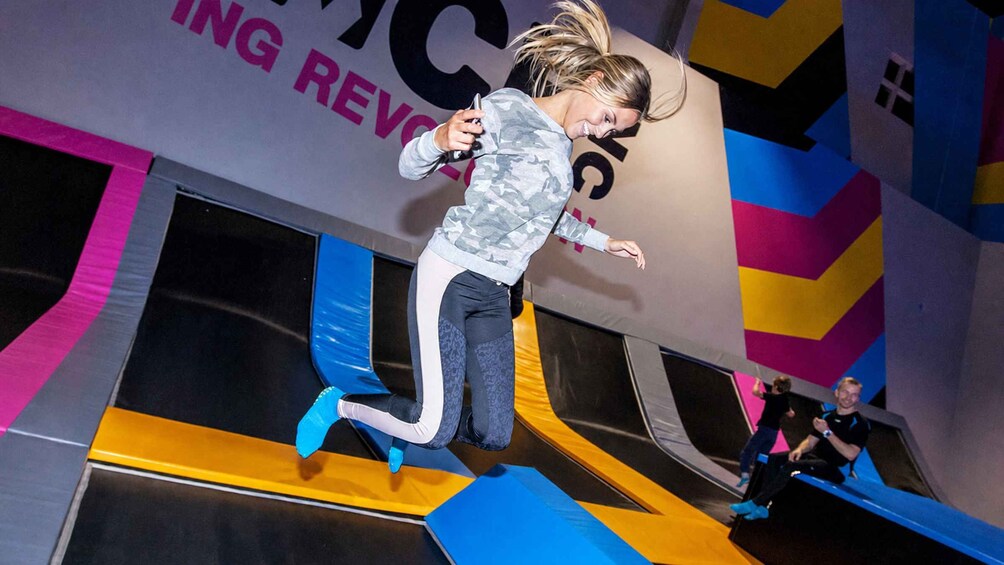 En person hopper på en trampolin foran et farverigt baggrund. 4
