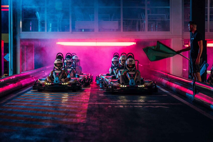 Go-karts racing on a track with neon lights. 2