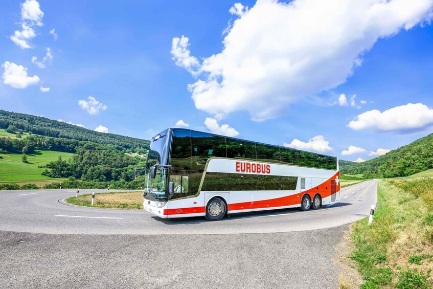 A Eurobus driving on a road with a scenic landscape in the background. 3