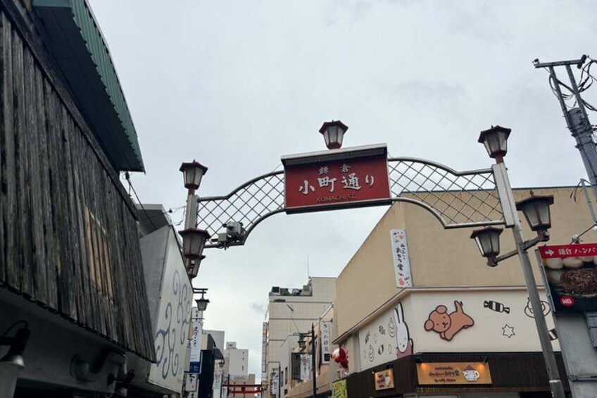 A street with a sign reading 'KOMACHI 9' and a building with a cartoon character on the wall. 2
