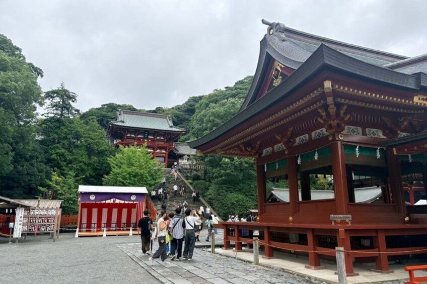 A traditional Japanese temple with a red gate, a wooden pavilion, and a staircase leading up to the temple. 5