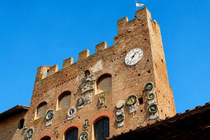 A historic brick tower with a clock, arched windows, and decorative elements. 2