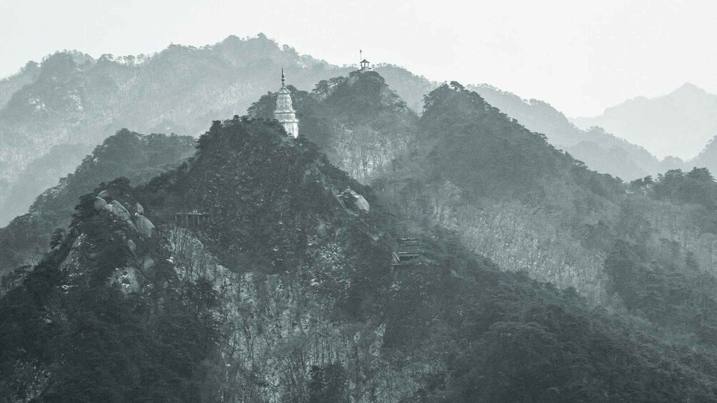 A misty mountain landscape with a prominent temple on a peak. 1