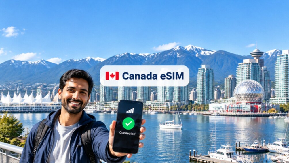 En person holder en smartphone med en Canada eSIM-logo, og i baggrunden ses en by og bjerge. 1