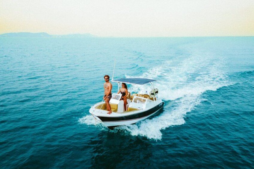 A small motorboat with two people on the water. 1