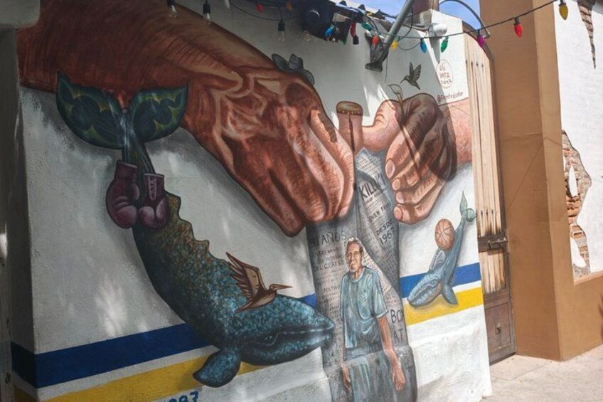 A mural with hands, a fish, and a person. 5