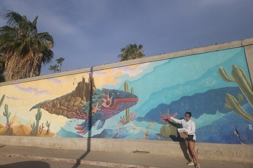 A mural of a large fish and cactus on a wall. 1