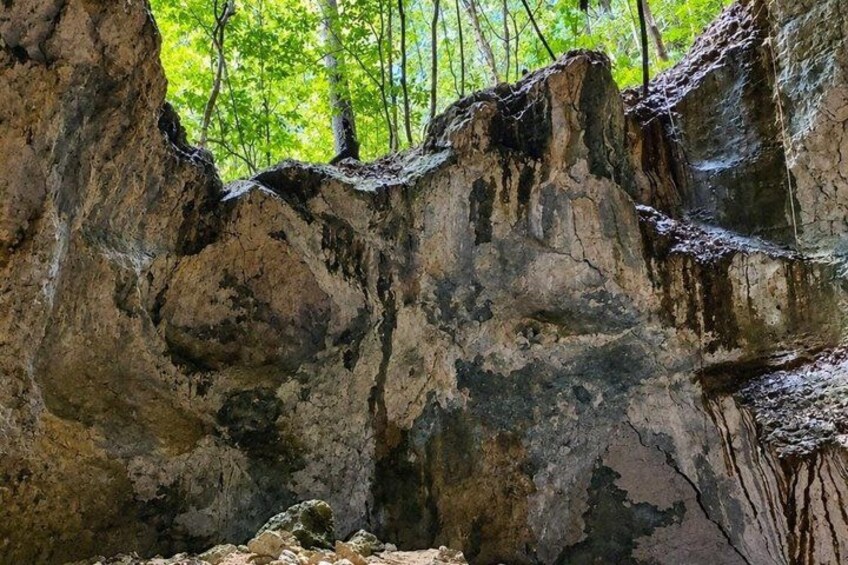 A rocky cliff with a cave entrance. 2