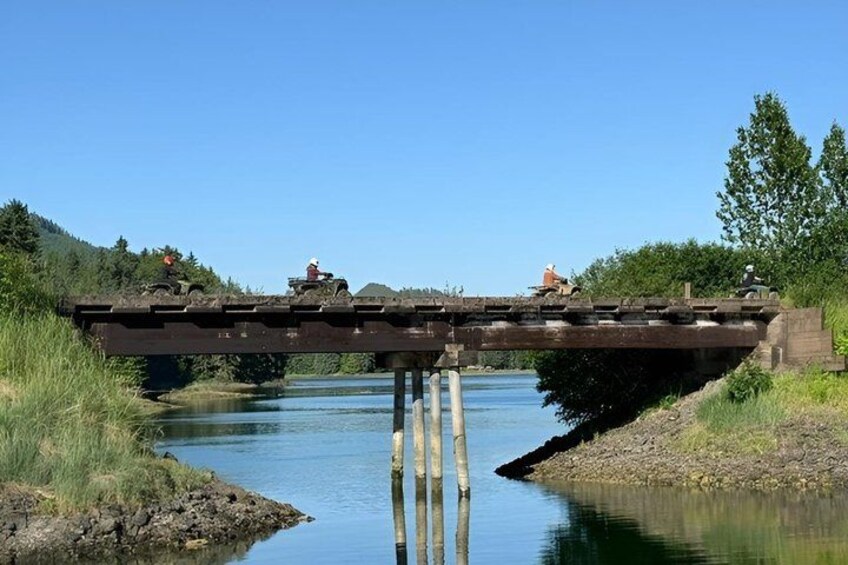 A wooden bridge over a river with a clear blue sky. 2