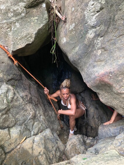 A person climbing a rocky terrain with a rope. 2