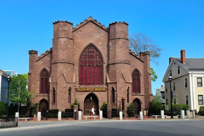 A historic brick church with arched windows and a central tower. 4