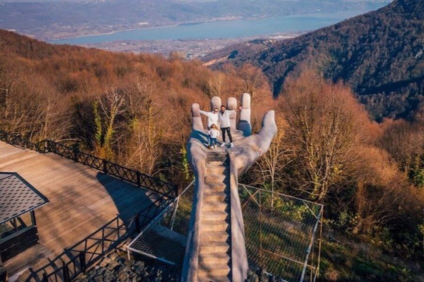 A wooden staircase leading to a viewing platform with a scenic overlook of a lake and mountains. 4