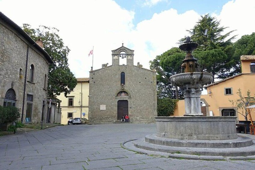 A town square with a church, a fountain, and surrounding buildings. 4