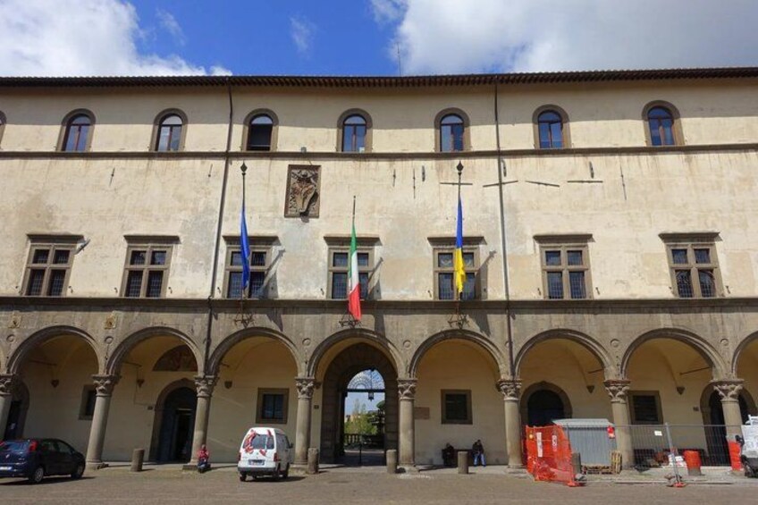 A historic building with arches, flags, and a clear sky. 5