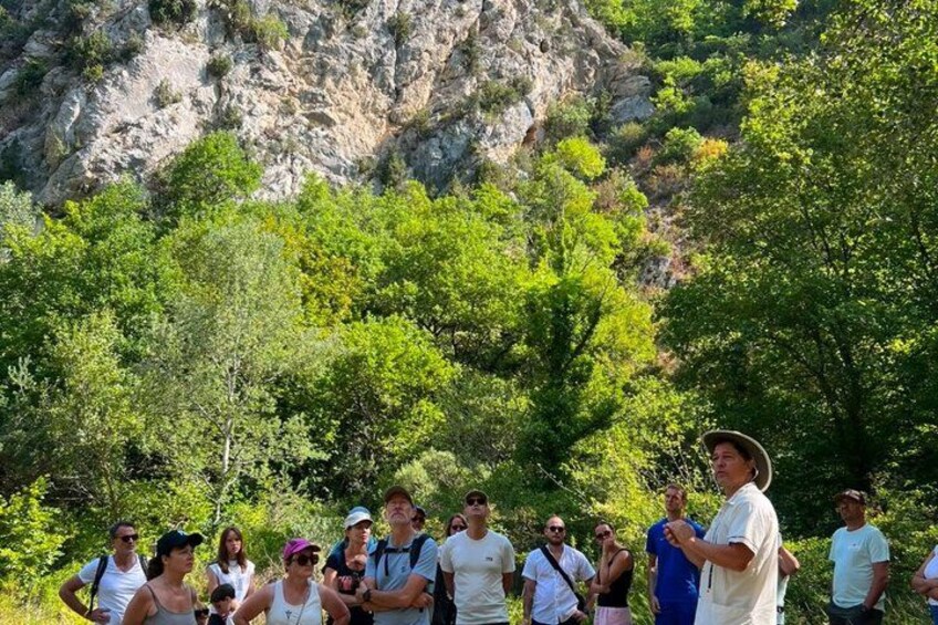 A group of people standing outdoors with a mountainous backdrop. 3