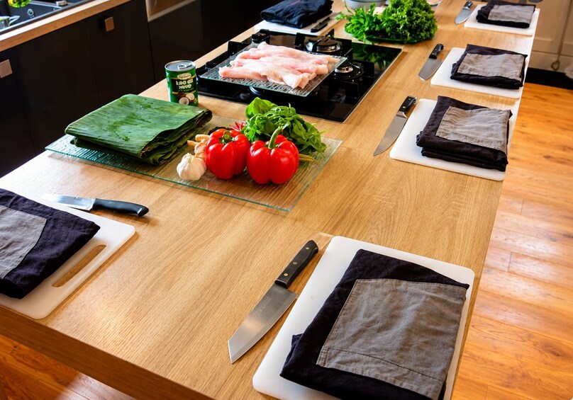 Un plan de travail de cuisine avec un gril, des légumes et des torchons pliés. 4