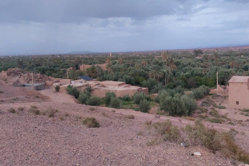 A rural landscape with sparse vegetation, a few buildings, and a distant horizon. 4