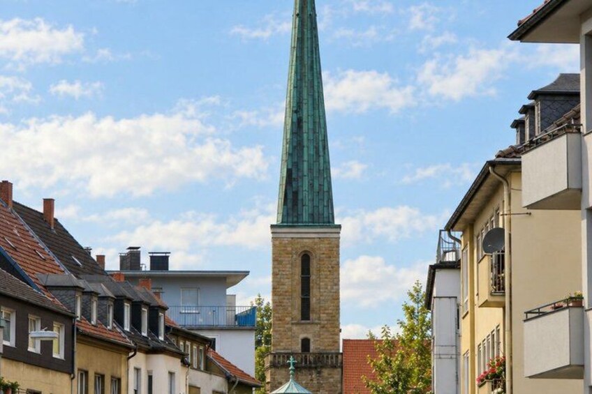 A church with a tall spire, surrounded by residential buildings. 5