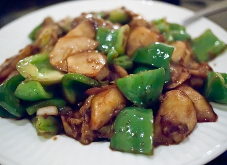 A plate of stir-fried chicken and green bell peppers. 5