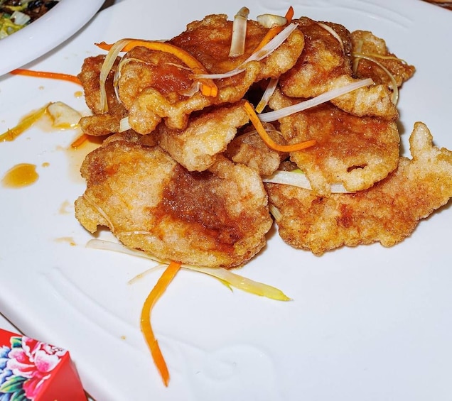 A plate of fried chicken pieces garnished with carrot strips and onion slices. 4