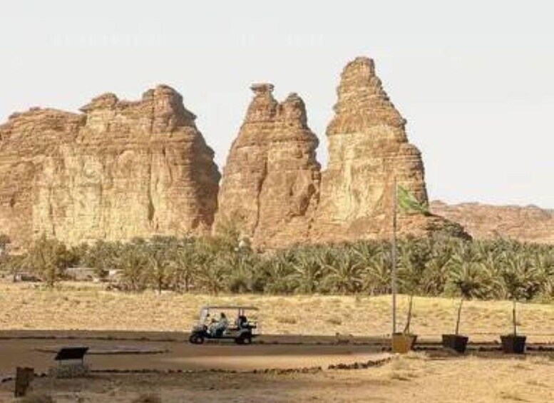 A jeep on a road with rock formations in the background. 3