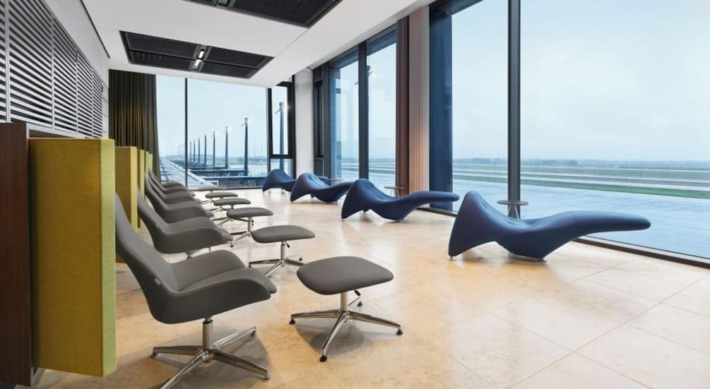 A modern waiting area with chairs and a view of a bridge. 3