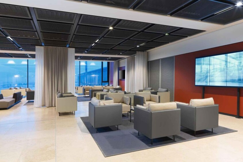 A modern conference room with tiered seating, large windows, and a projection screen. 4