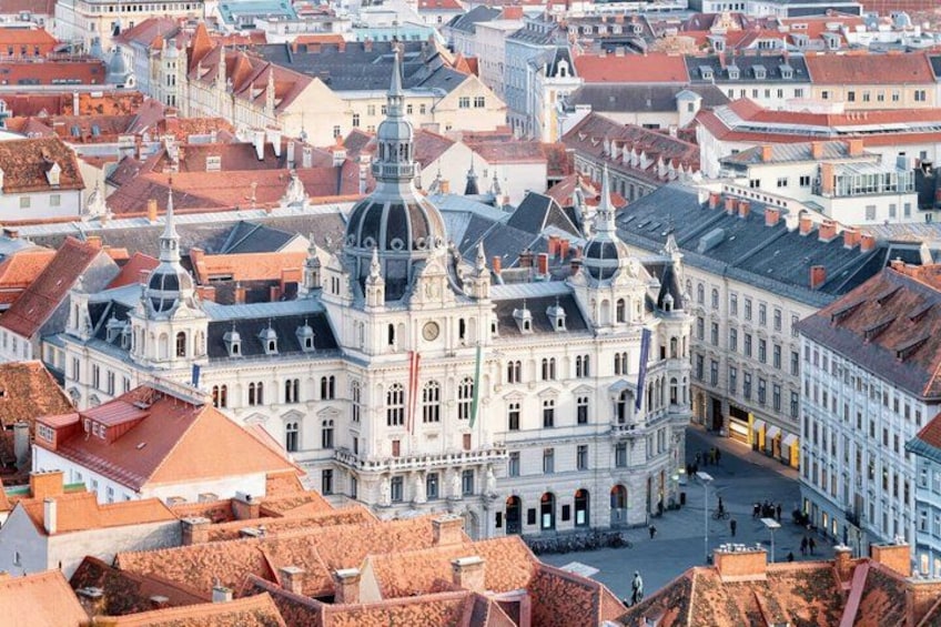 A historic cityscape with a prominent building featuring a dome and classical architecture. 1