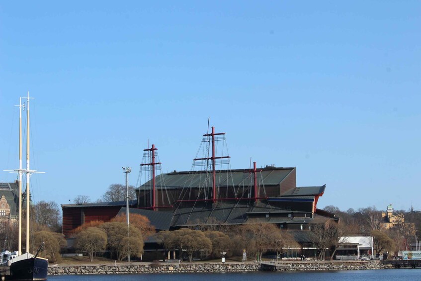 Un grand bâtiment doté d’un toit en pente et de plusieurs mâts sur lesquels flottent des drapeaux rouges. 4