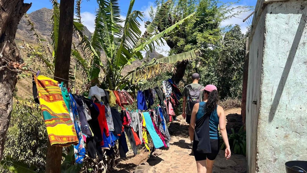 A person walking towards a clothesline with various garments hanging. 1